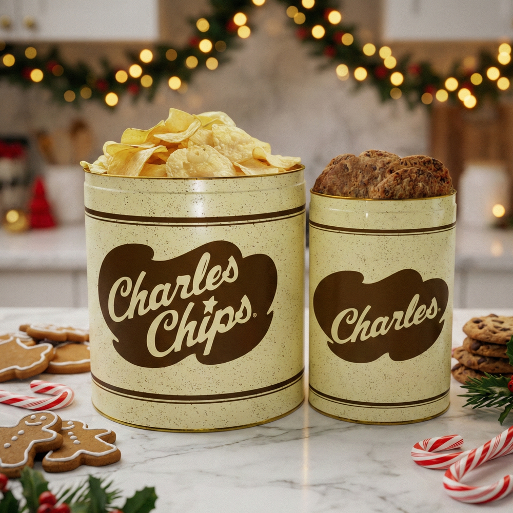Two 'Charles Chips' tins on a table with Christmas decorations in the background