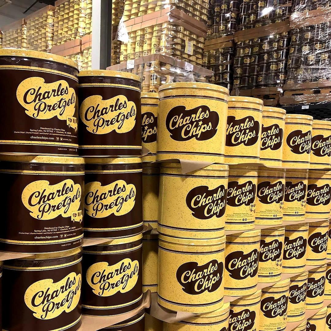 Pallets of Charles Chips and Charles Pretzels tins in the warehouse
